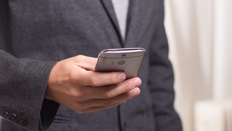 スマホでLINEメッセージを打つ登校班遅刻連絡のイメージ